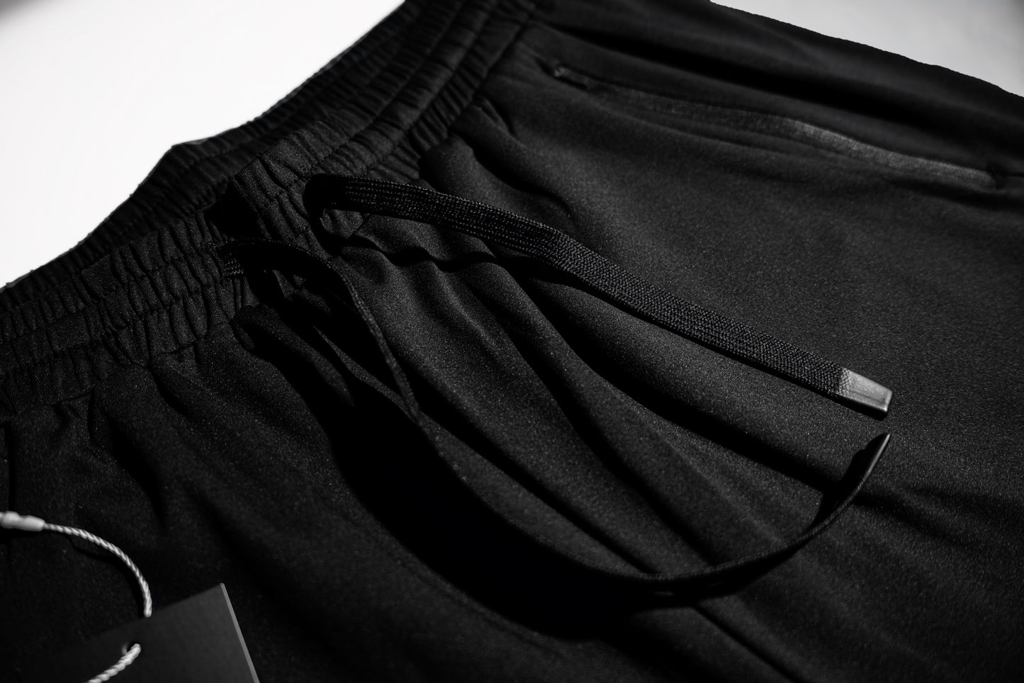 Macro detail of the flat drawstring and elastic waistband on the Fitra Core Short
