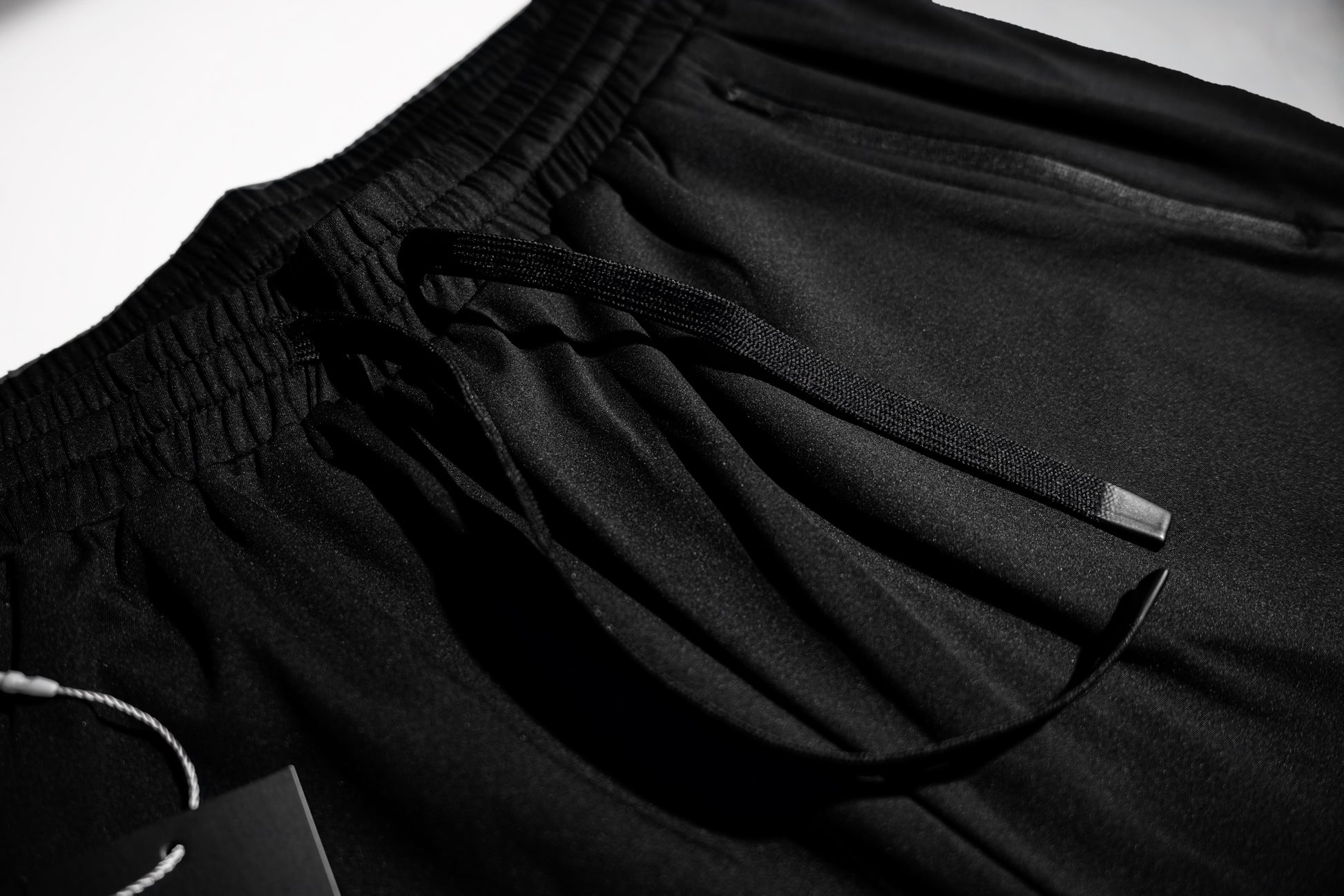 Macro detail of the flat drawstring and elastic waistband on the Fitra Core Short