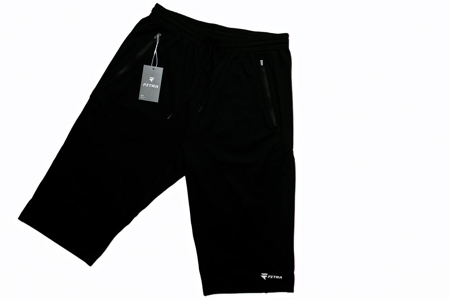 Fitra Core Short in black, angled flat lay showing drawstring waistband, zippered side pockets and hang tag